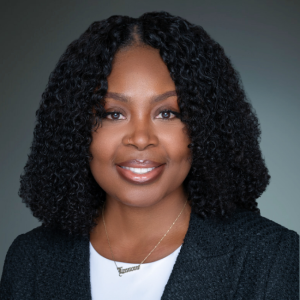 Lamone Graham – ADR Mediator Headshot A professional headshot of Lamone Graham, a smiling Black woman with short curly hair, wearing a dark jacket and a nameplate necklace, radiating confidence and approachability.